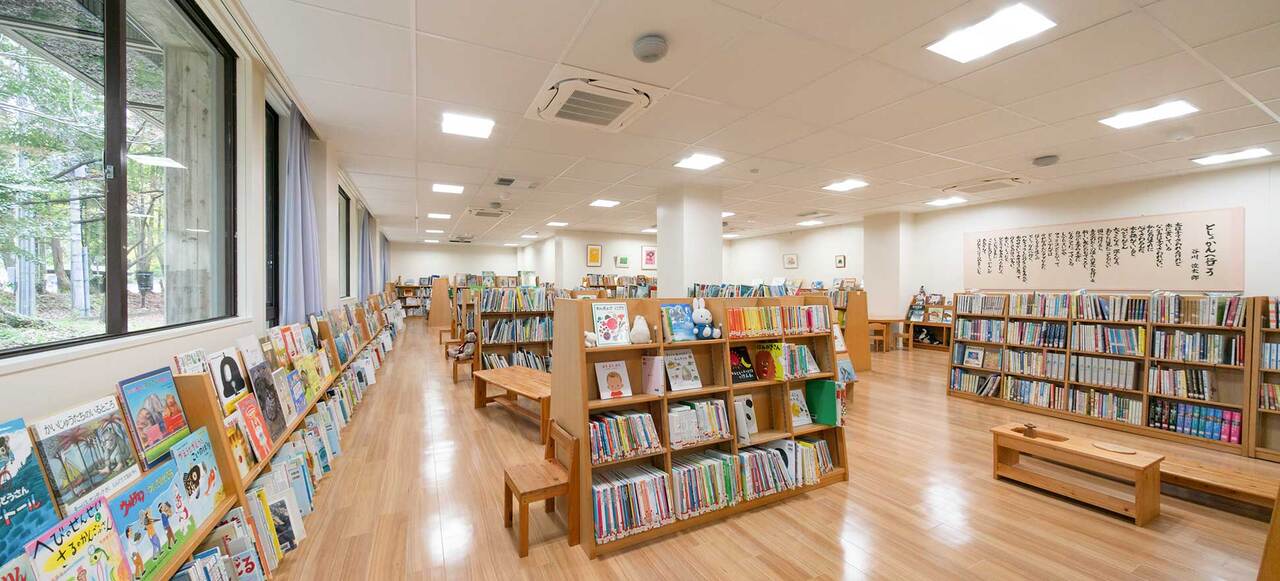 写真:図書館の中の様子。本棚にたくさんの本が並んでいます。壁には絵や詞が飾ってあります。木でできた椅子があります。