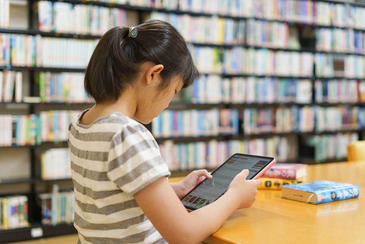 写真：女の子がタブレットを見ています