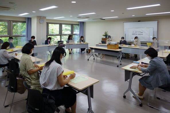 写真：総会で理事が報告しています。