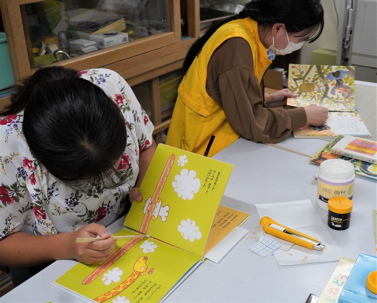 写真：高知大学えんむすび隊の学生さんが本の修理をしています。