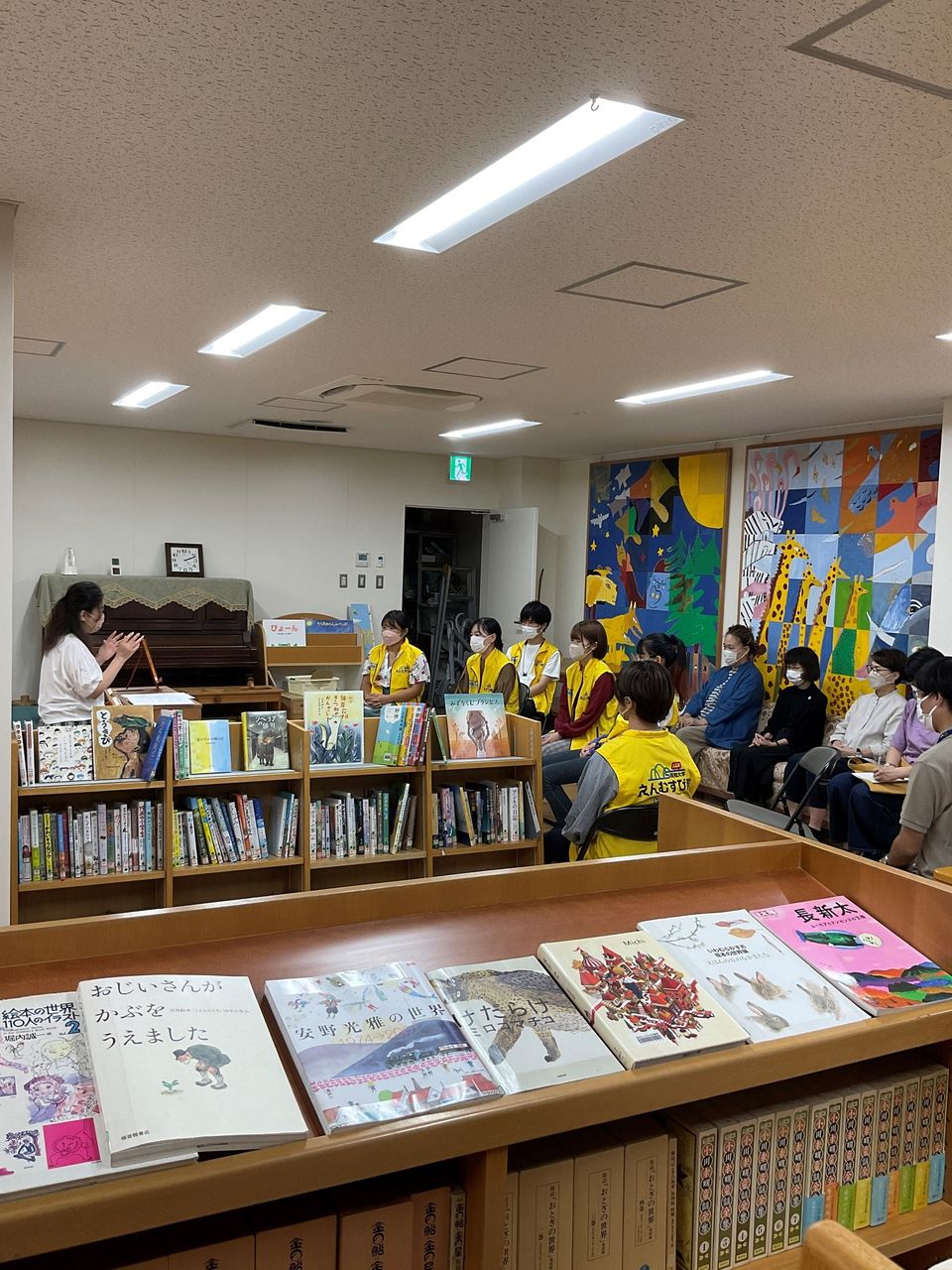 写真：職員の大木が参加者に絵本の解説をしています。