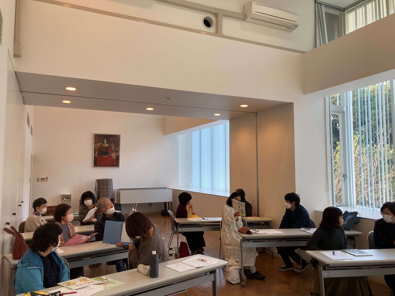 写真：講座参加者がペアで絵本を読み合っています。