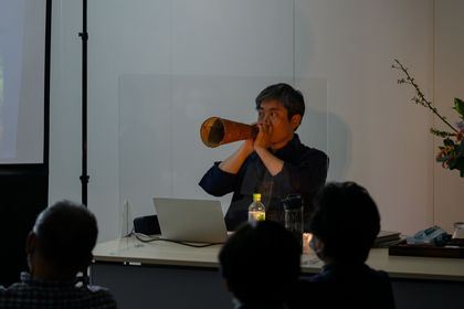 写真：大竹さんがトナカイの鳴き声を真似る道具を吹いています。