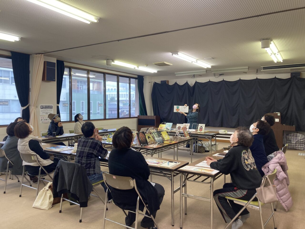 写真：参加者と講師が上を向いて発声練習をしています。