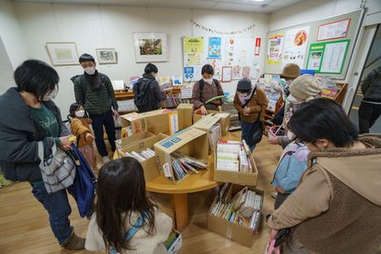写真：館内で、バザーに来たお客様が、購入する本を選んでいます。