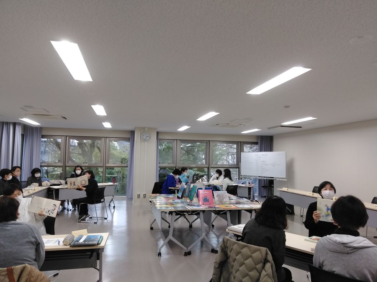 写真：受講者の皆さんがグループで絵本を読み合っています。