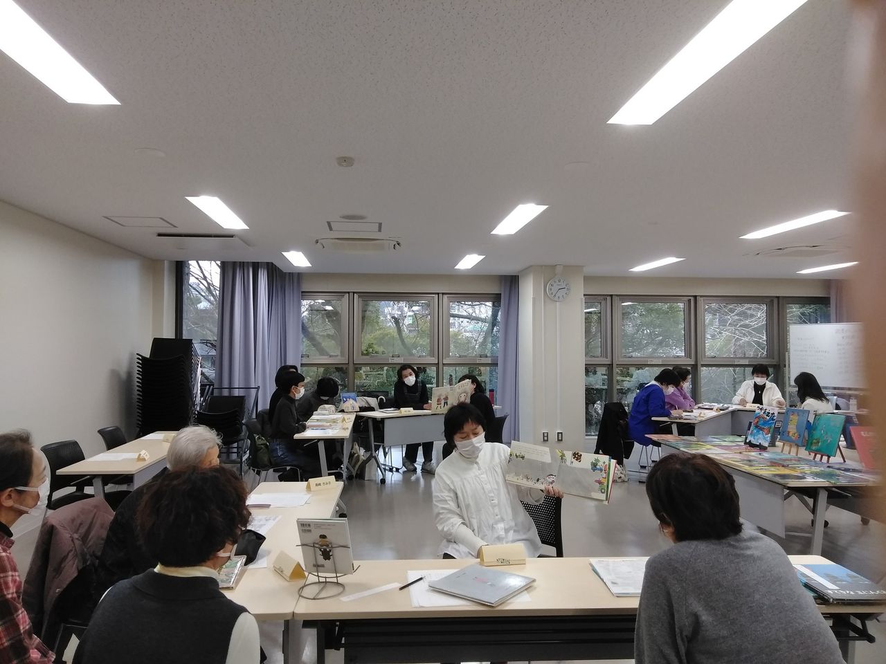 写真：受講生の皆さんが絵本を読み合っています。