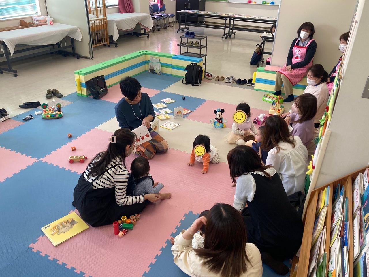 写真：赤ちゃんと保護者に絵本を読んでいます。
