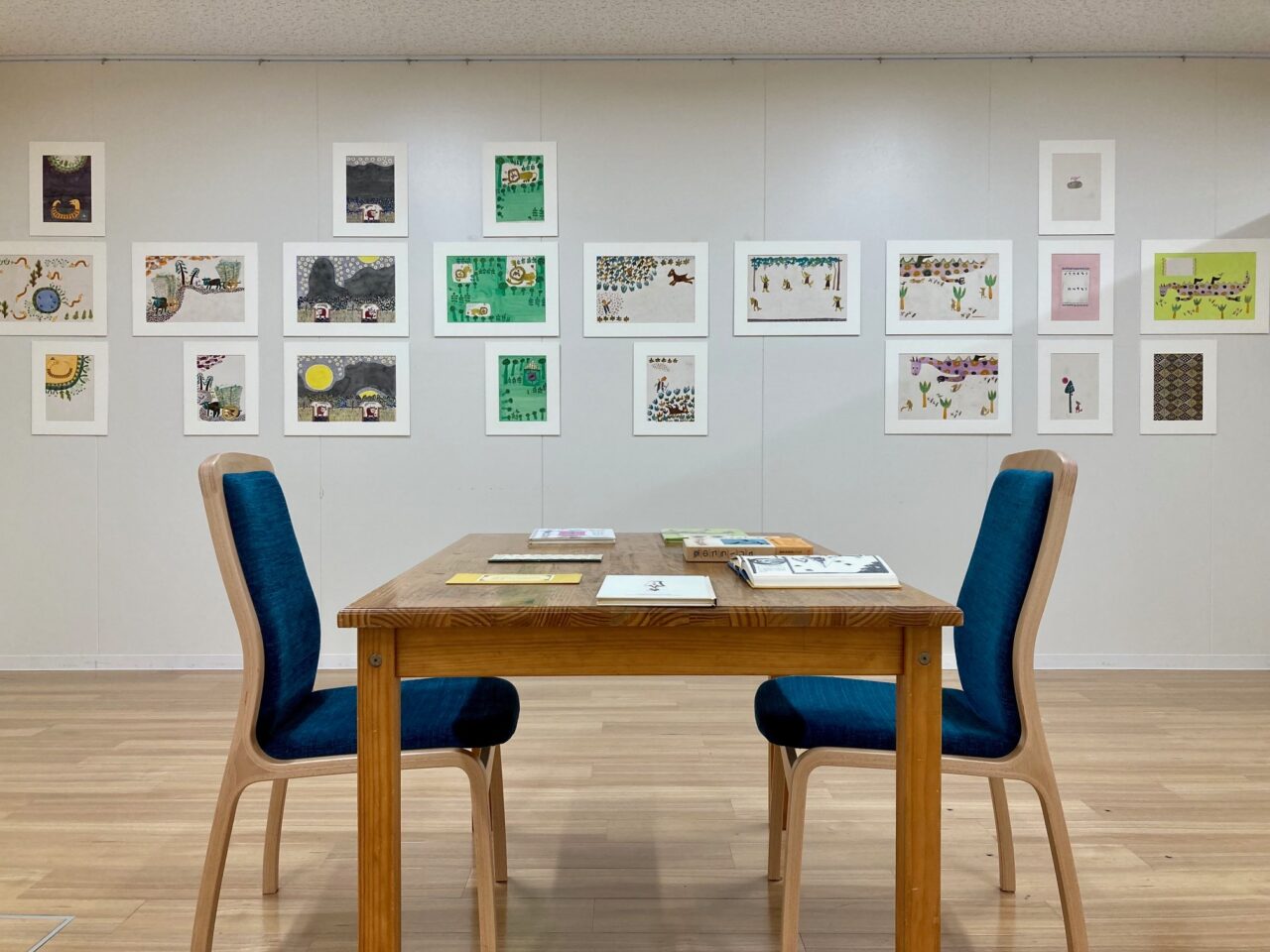 写真：机と椅子です。壁に原画が飾られています。