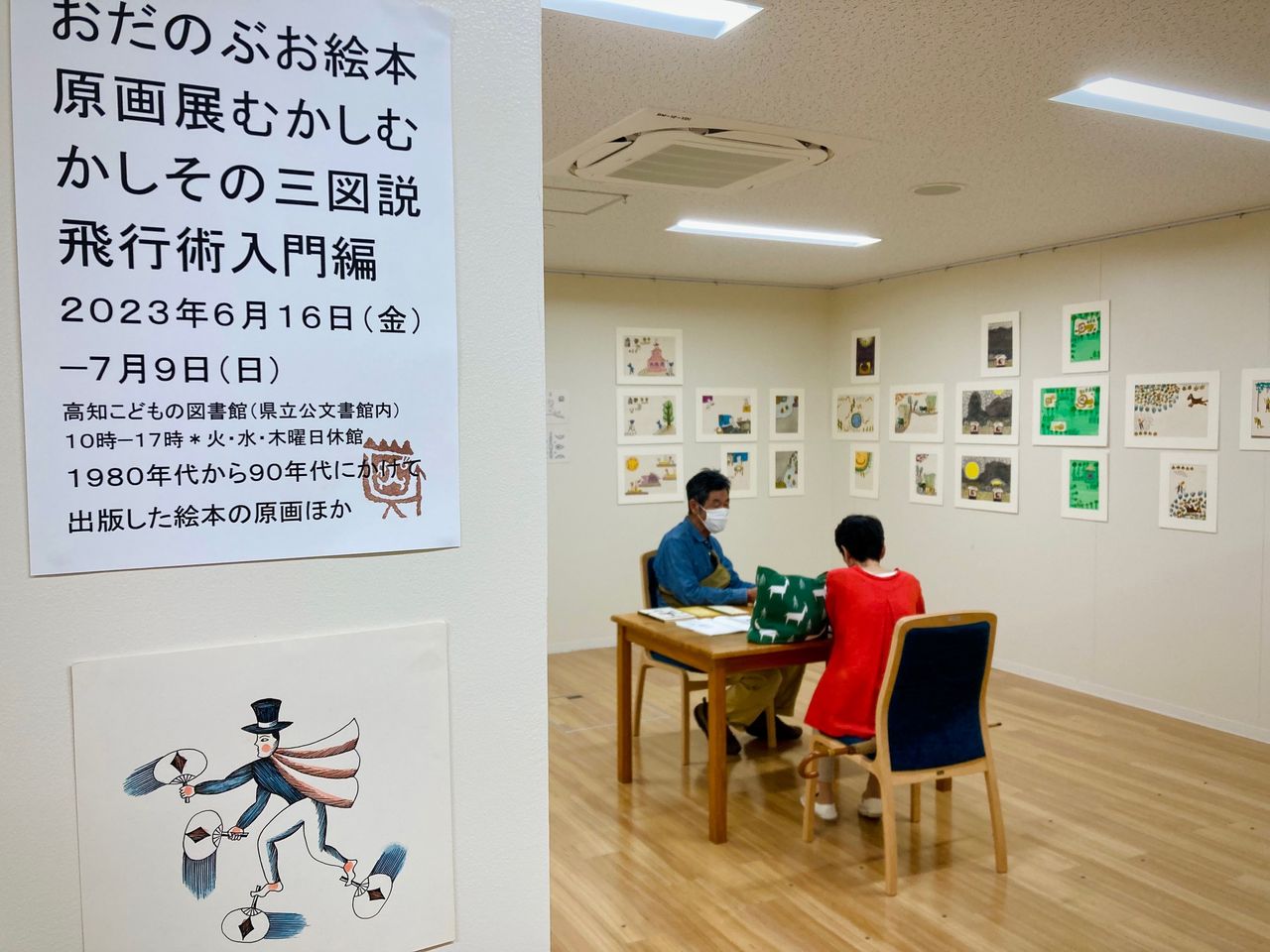 写真：織田信生さんとお客様がギャラリーあとりえほんのテーブルで話をしています。