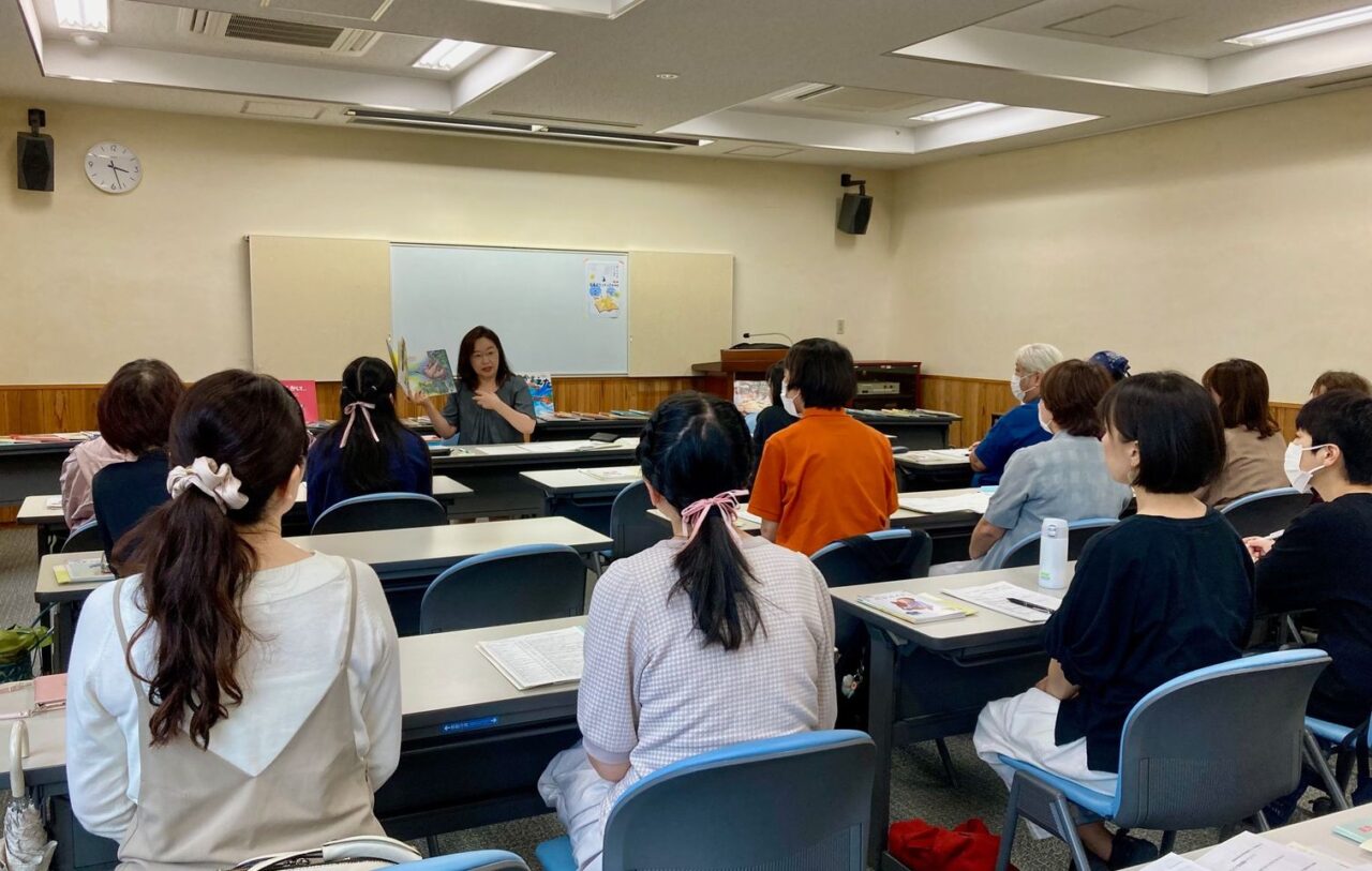 写真：スタッフ大木が読み聞かせについて説明しています。