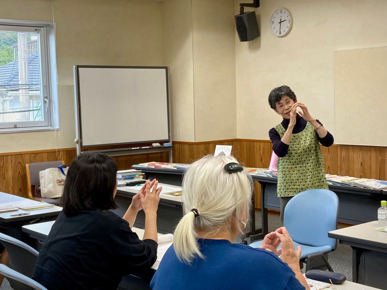 写真：ストーリーテラーの森尾さんが手遊びのレクチャーをしています。