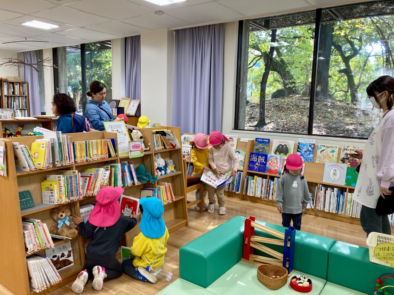 写真：園児が本棚から絵本を選んでいます。