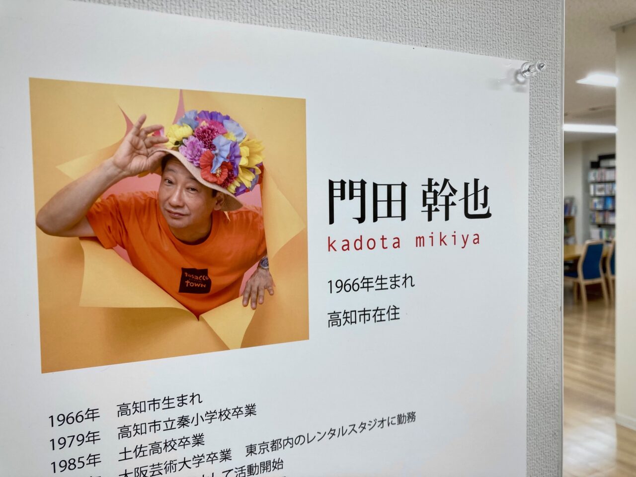 写真：門田カメラマン帽子に手