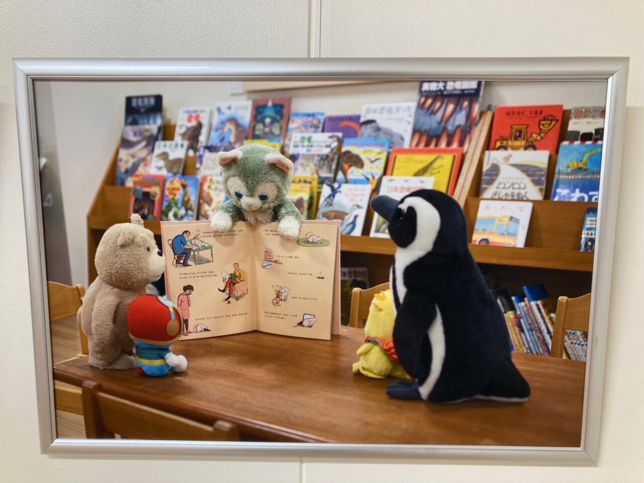 写真：本の読み聞かせをするぬいぐるみ