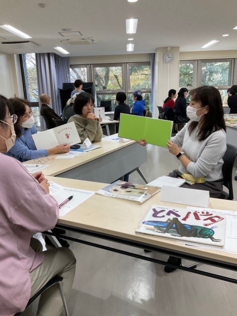 写真：講師と参加者が絵本の読み方について学んでいます。