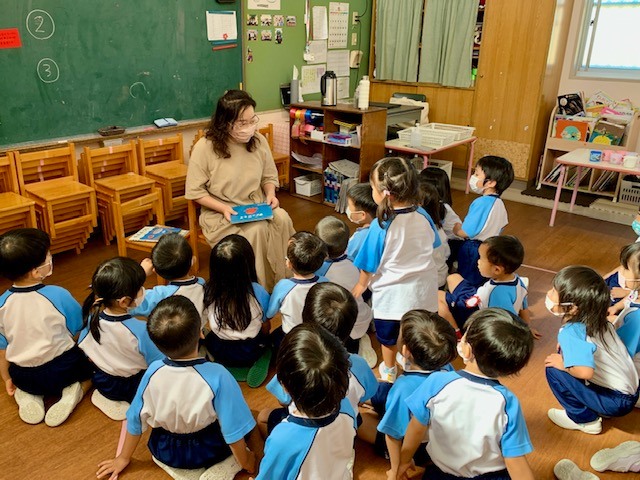 写真：当館司書大木がこどもたちに本を読んでいます。