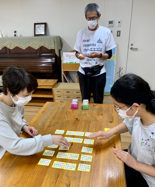 写真：利用者さんが百人一首をしています。
