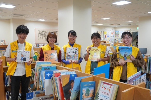 写真：高知大学えんむすび隊のみなさんが本を持っています。