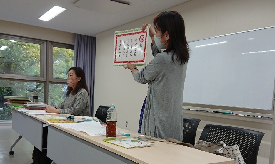 写真：講師の花房さんがカードを手に説明しています。