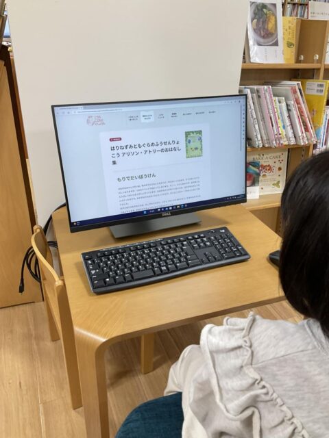 写真：小さな利用者さんが館内閲覧用パソコンの前に座っています。