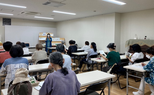 写真：絵本の時間を聞いている受講生の皆さんです。
