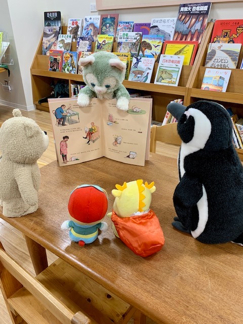 写真：ぬいぐるみが絵本を読み聞かせしています。