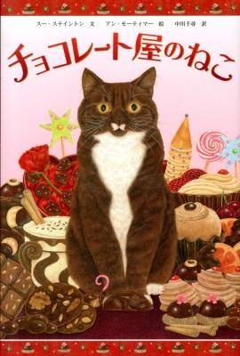 本の表紙：真ん中にすわる茶色のねこ　まわりにお菓子
