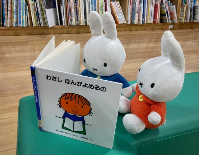 写真：うさこちゃんのぬいぐるみがブルーナの絵本を読んでいます。