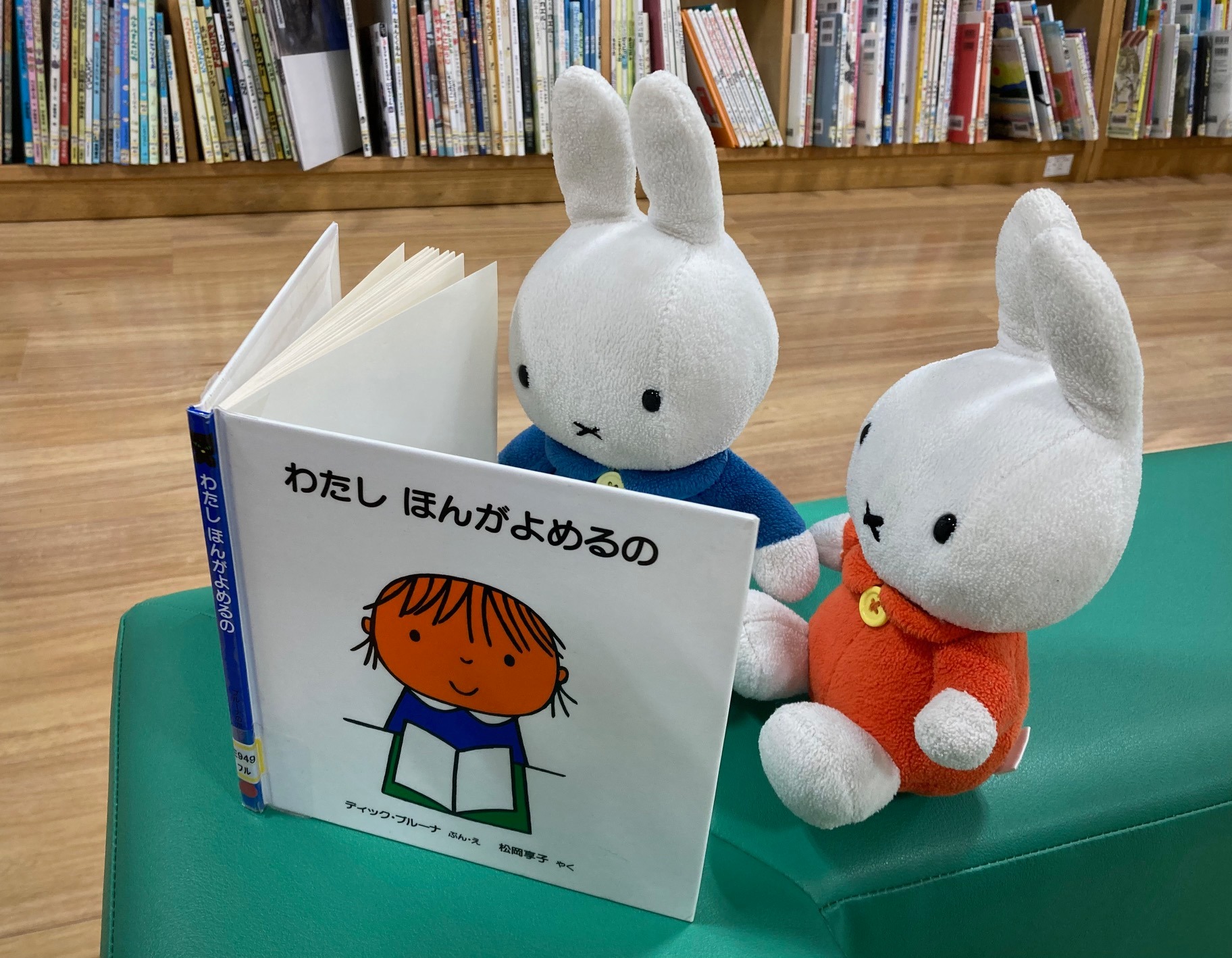 写真：うさこちゃんのぬいぐるみがブルーナの絵本を読んでいます。