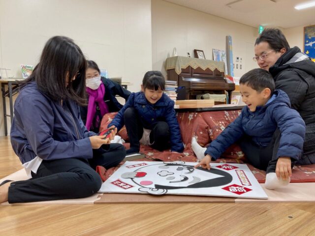 写真：家族で福笑いをしています。